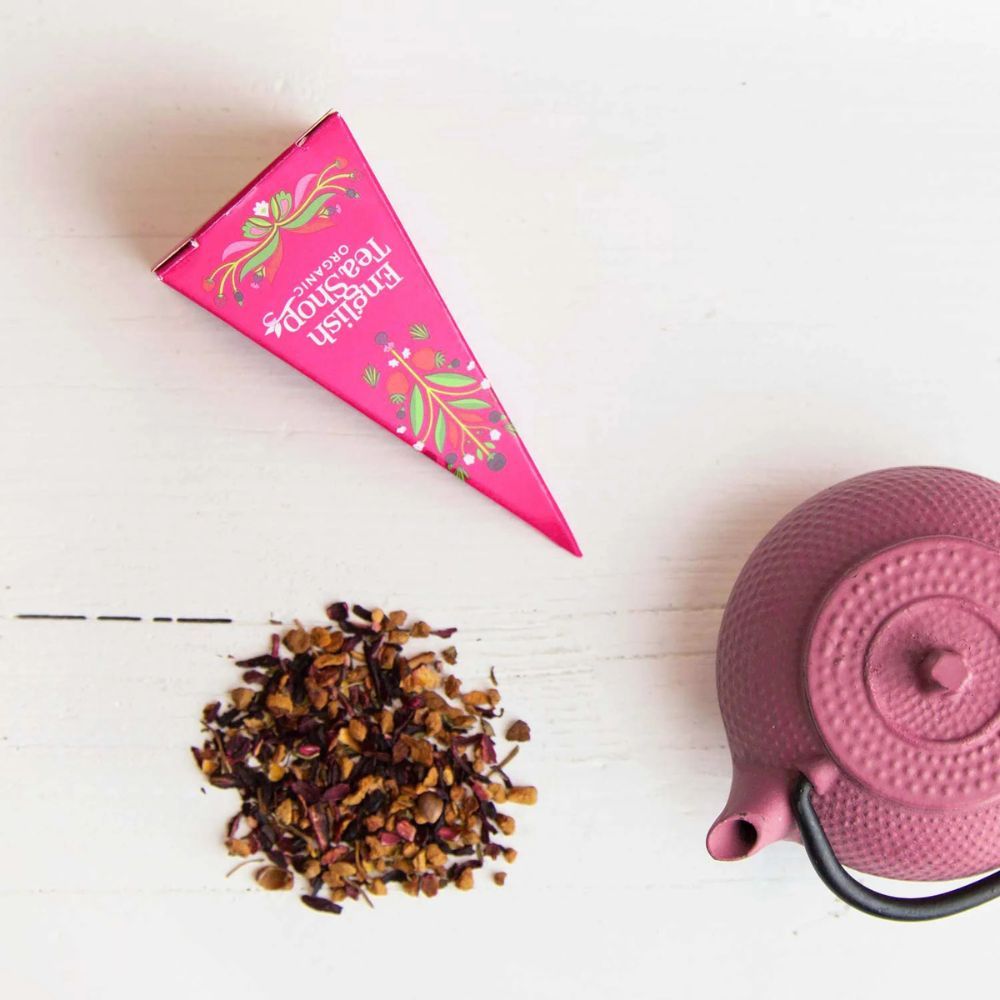 Rosa Pyramidenbox und Teekanne mit losem Tee. Aufschrift: English Tea Shop Organic. Teebeutel mit Aufschrift Earl Grey.