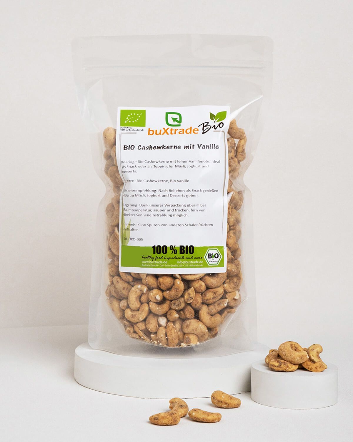 Bio Cashewkerne mit Vanille in transparenter Verpackung, daneben einige Kerne.