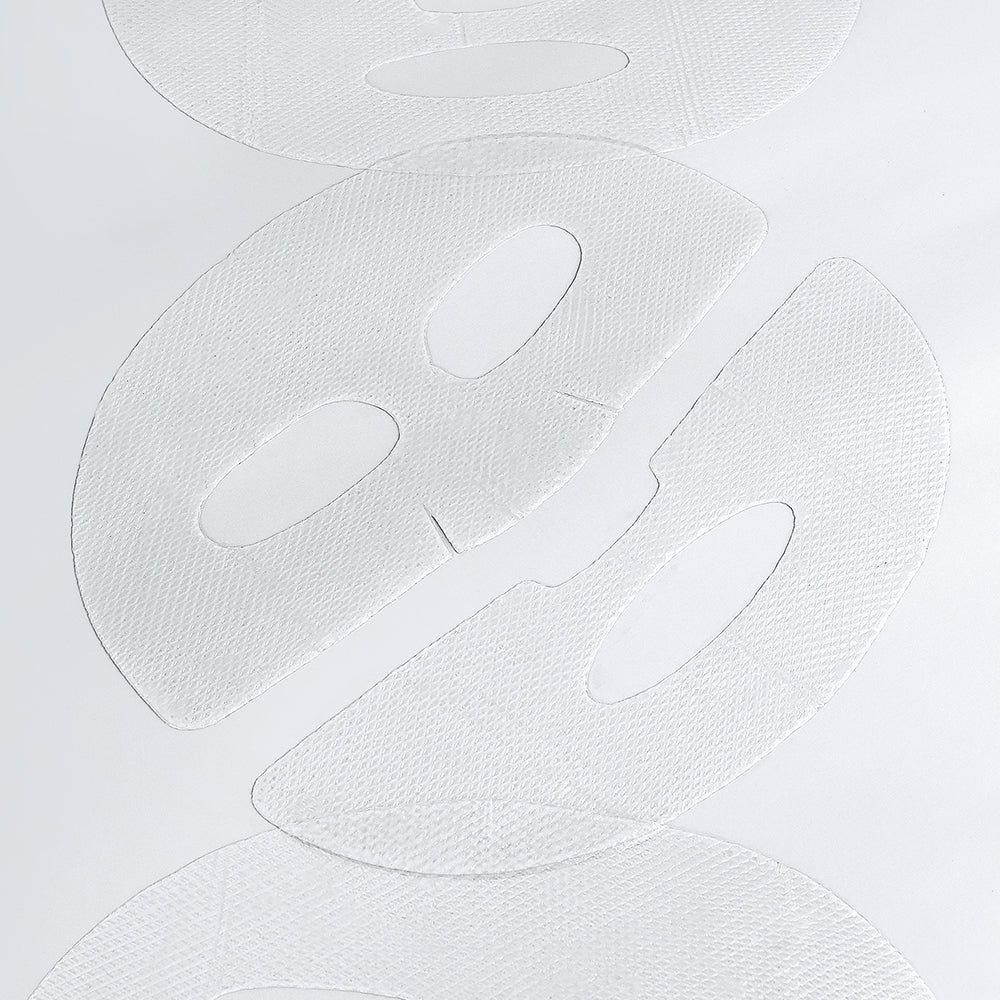 Nahaufnahme von drei weißen Gesichtsmasken mit Aussparungen für Augen und Mund.