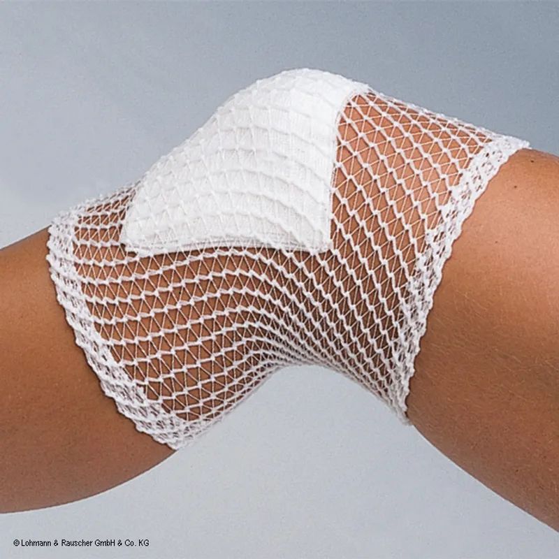 Weiße Netzbandage um ein Kniegelenk, mit einer zusätzlichen Polsterauflage.