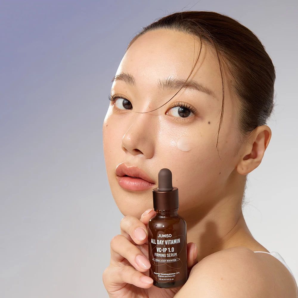 Frau mit JUMISO All Day Vitamin VC-IP 1.0 Firming Serum Flasche, die auf ihre Haut aufträgt.