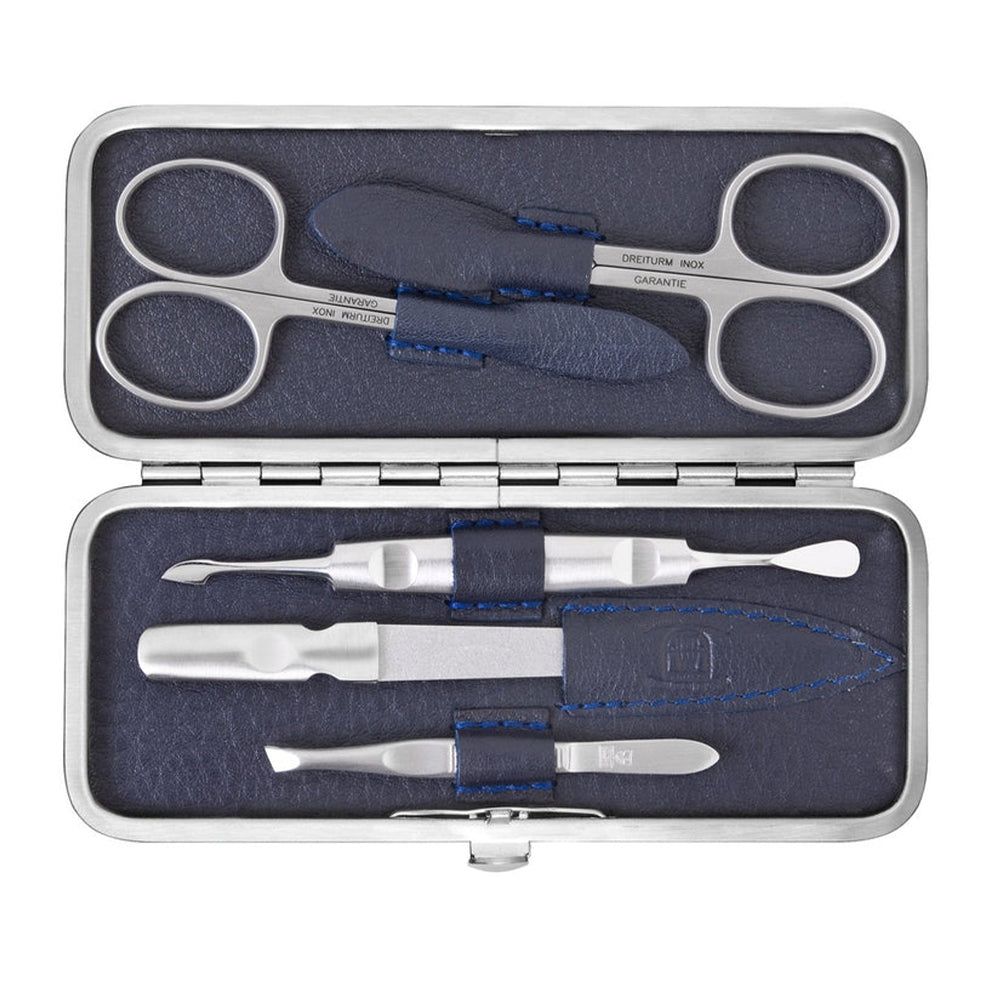 Maniküre-Etui mit silberfarbenen Werkzeugen. Enthält Schere, Feile und weitere Instrumente. Blaues Lederfutter. Geöffnet.