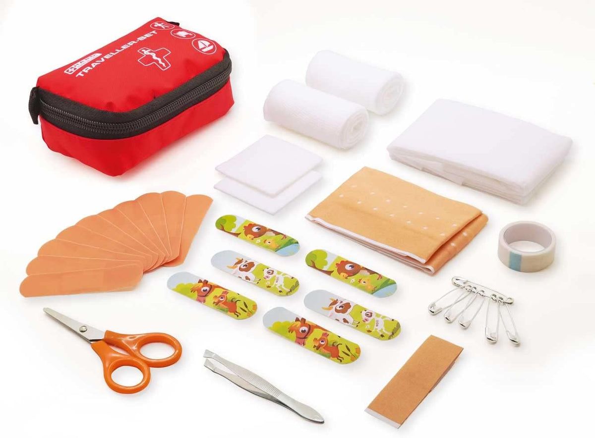 Geöffnete rote Erste-Hilfe-Tasche mit Verbandsmaterial, Pflastern, Schere, Pinzette und Sicherheitsnadeln. Enthält auch Mullbinden und Klebeband.