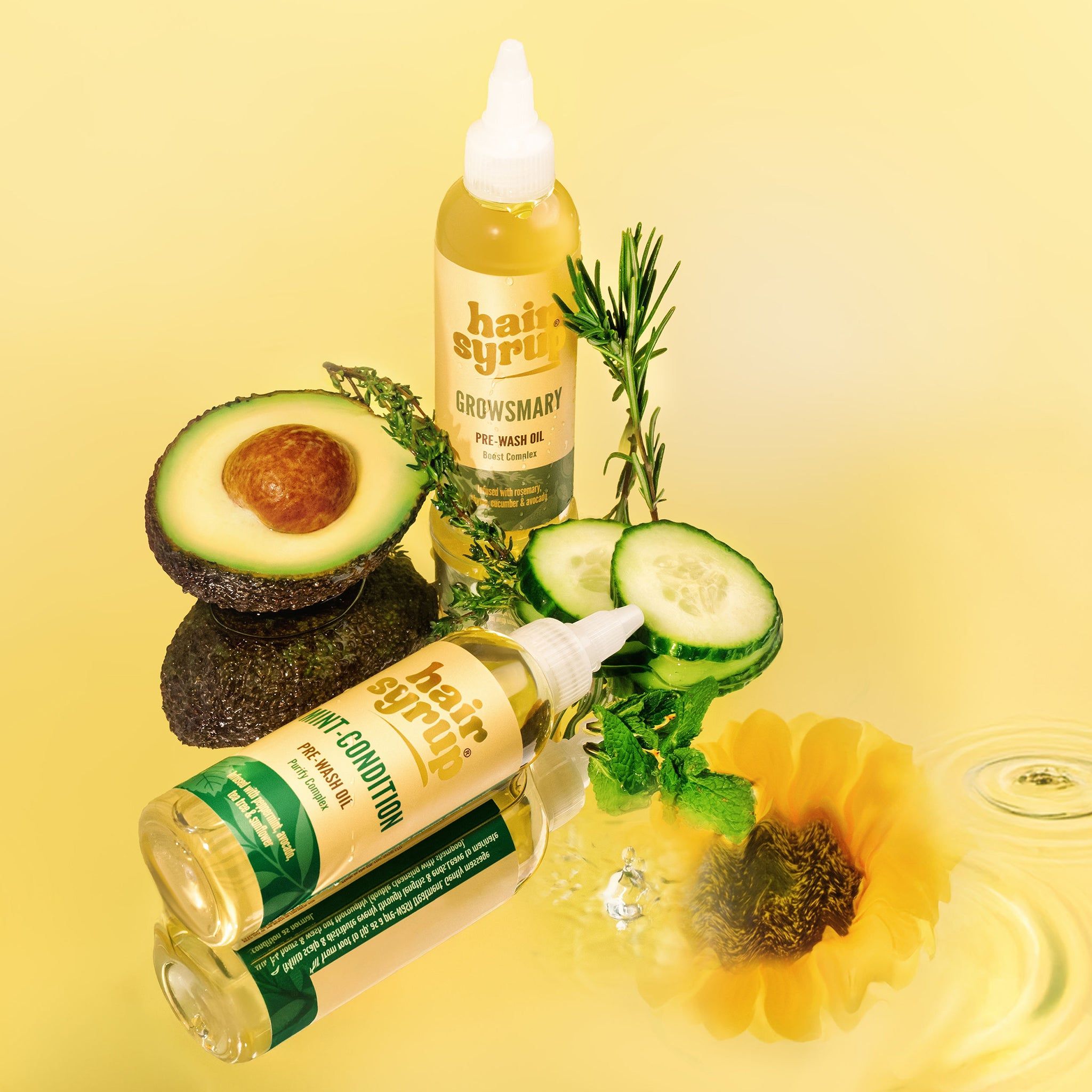 Zwei Flaschen „Hair Syrup Growsmary“ mit Avocado, Gurke, Rosmarin und Sonnenblume. Auf gelbem Hintergrund.