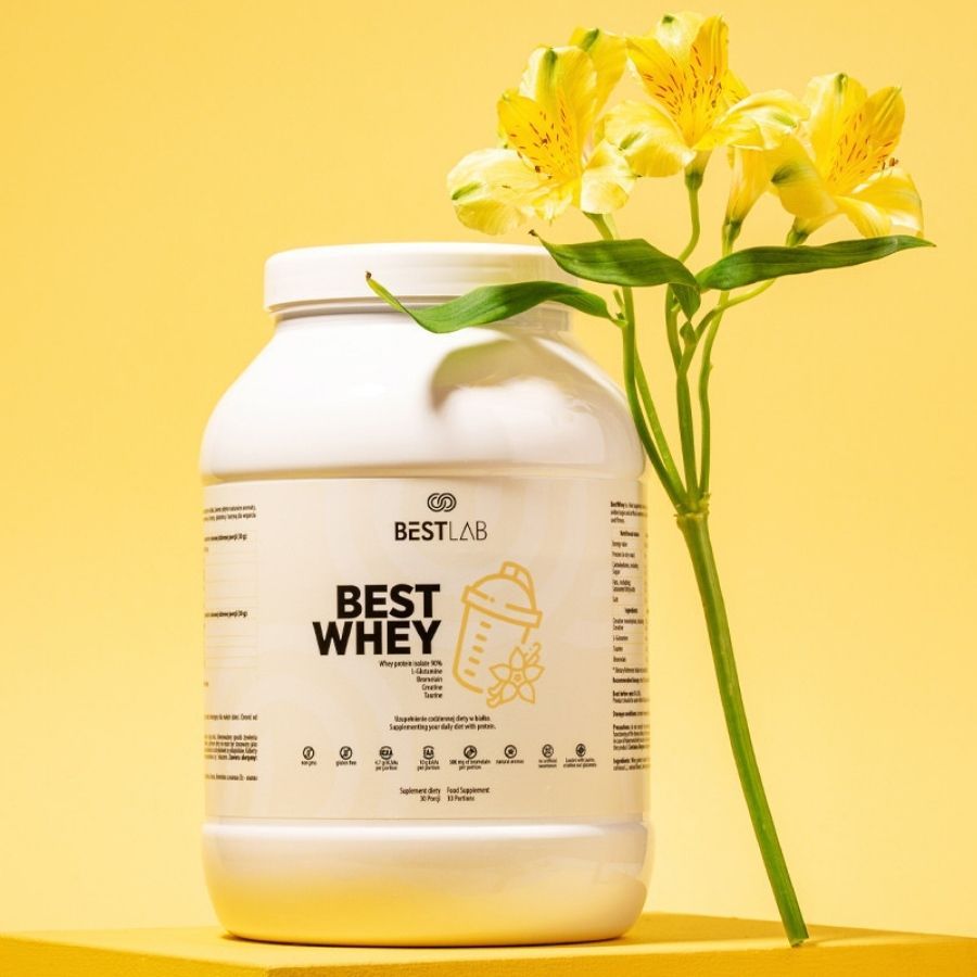 Weißes Best Lab Whey Proteinpräparat vor gelbem Hintergrund. Logo und Schriftzug "BEST WHEY" auf der Vorderseite. Mit gelben Blumen.