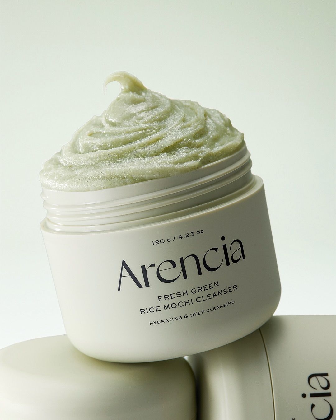 Beige Tiegel mit grünem Mochi-Reiniger. Aufschrift: Arencia, Fresh Green Rice Mochi Cleanser, Hydrating & Deep Cleansing.