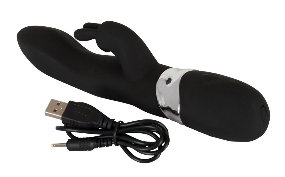 Schwarzer Vibrator mit Ohren und silberfarbenem Band. USB-Ladekabel liegt daneben.