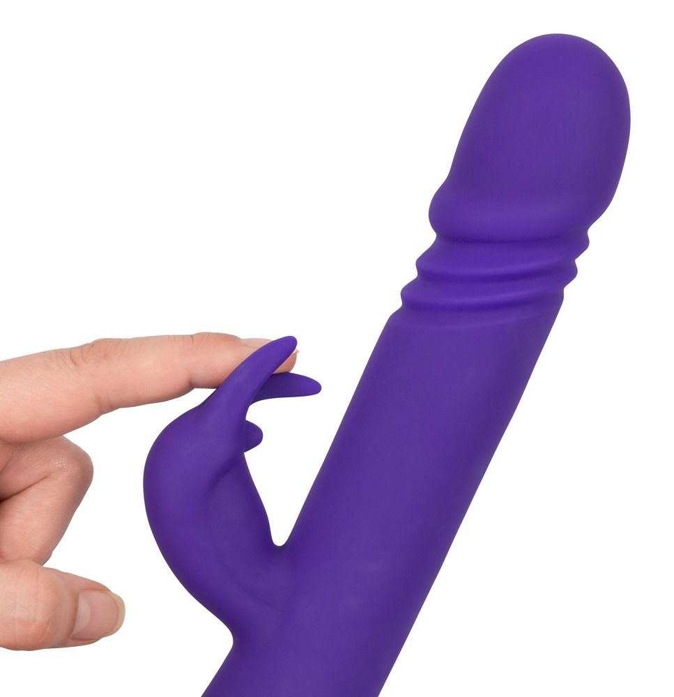 Lila Vibrator mit Klitorisreizarm. Finger berühren den Reizarm. Auf weißem Hintergrund.