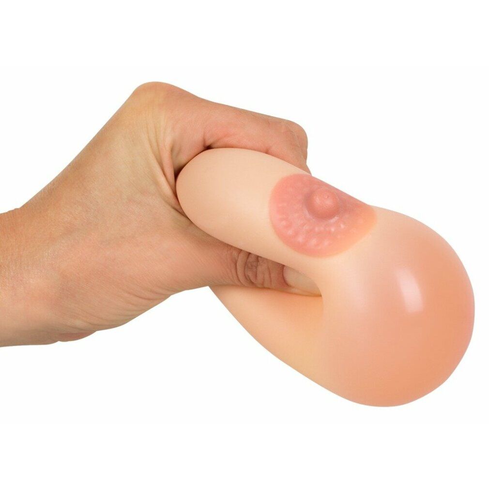 Eine Hand drückt eine Squeeze-Ball-Brust zusammen. Rosa Brustwarze. Hautfarbenes Material.