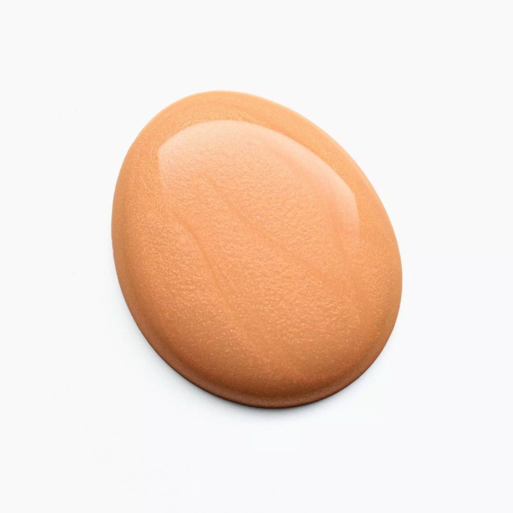 Pfirsichfarbener Nagellacktropfen auf weißem Hintergrund. Glänzende Oberfläche.