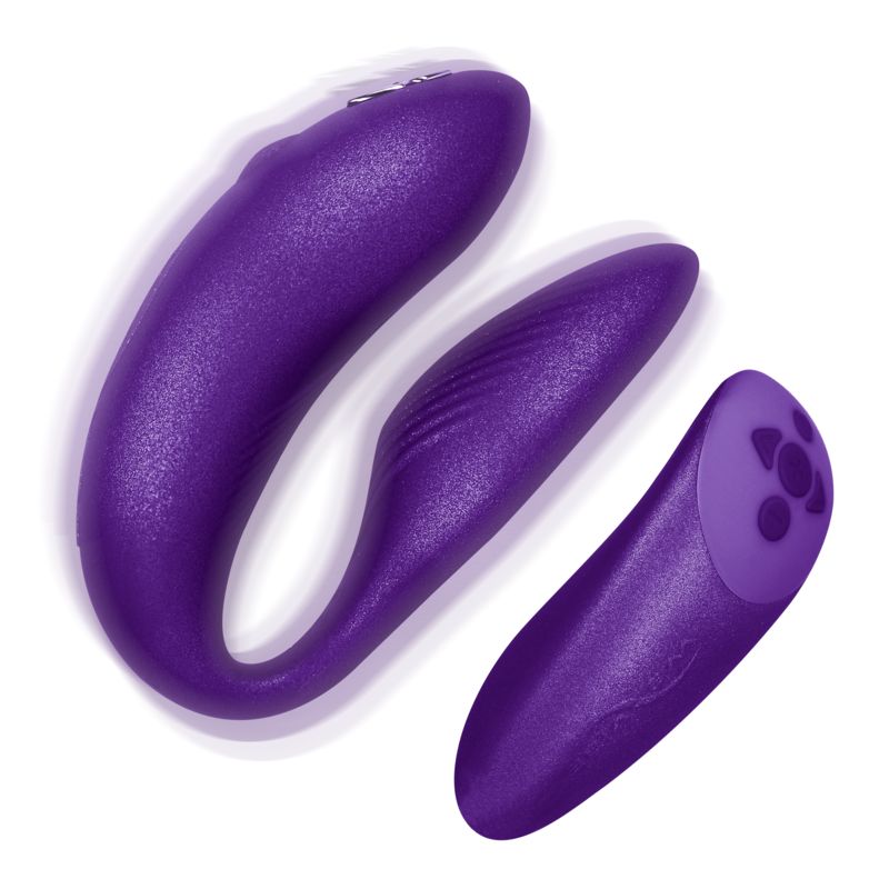 Lila Vibrator für Paare. U-förmig mit einem separaten, länglichen Bedienelement. Oberflächenstruktur erkennbar.