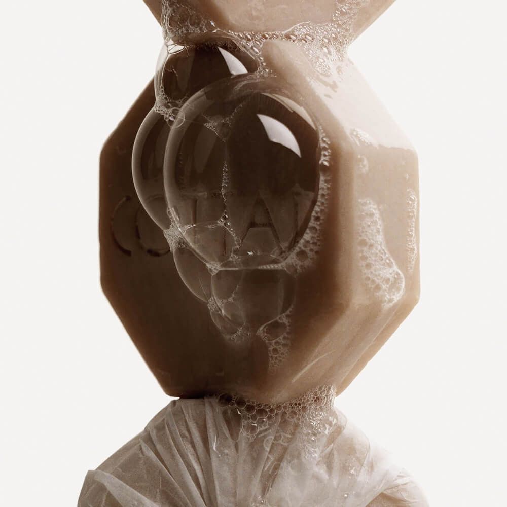 Achtkantige Seife mit Blasen. Die Seife ist hellbraun und trägt den Schriftzug COTTAN.