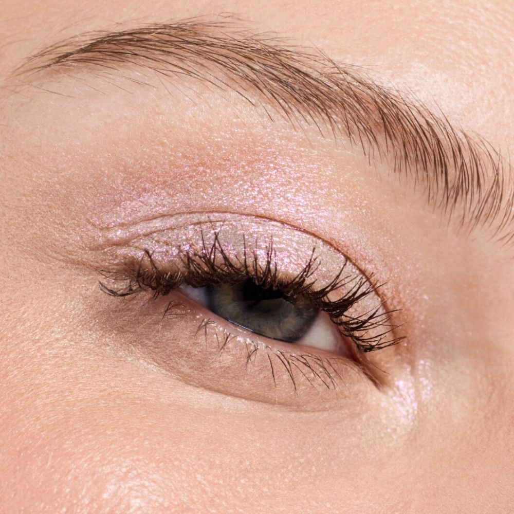 Auge mit rosa Lidschatten. Wimpern getuscht. Haut mit Make-up.