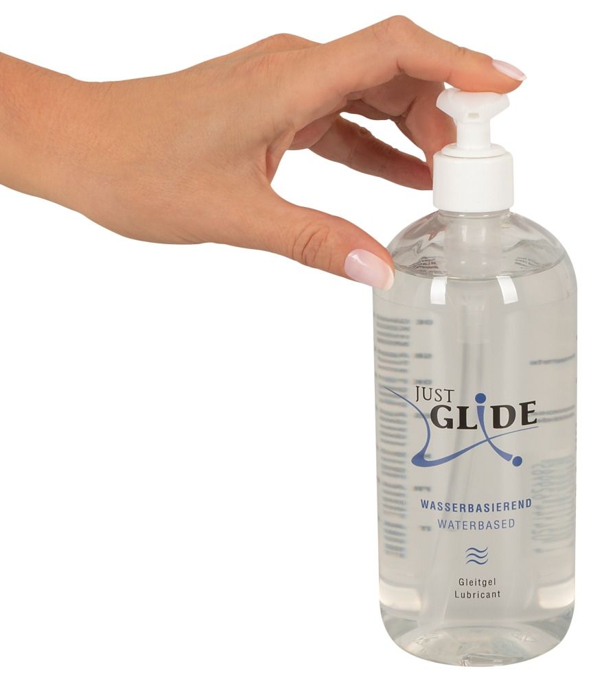 Hand hält eine transparente Flasche mit Dosierpumpe. Aufschrift: JUST GLIDE, Wasserbasiert.