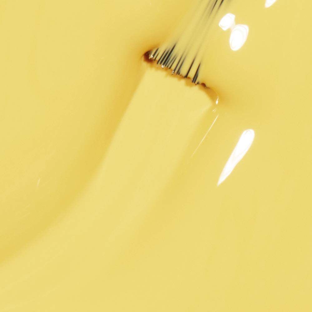 Gelber Nagellack mit Pinsel. Nahaufnahme, Pinsel in Lack getaucht.