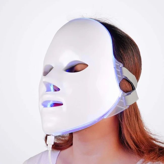 Weißes Gesichtsmaske-Design auf einem Gesicht. Sichtbare LED-Beleuchtung. Kabelanschluss.
