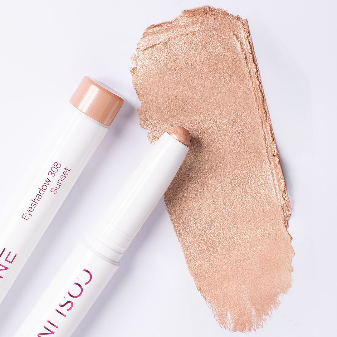 Zwei weiße Stift-Lidschatten und ein Swatch. Aufschrift: "Eyeshadow 308 Sunset". Die Spitzen sind in einem hellen Farbton gehalten.