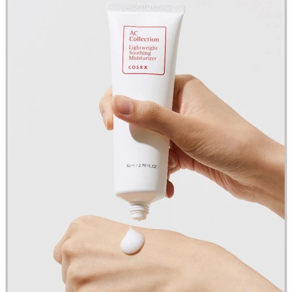 Hände halten eine Tube. Creme wird auf die Hand gedrückt. Auf der Tube: AC Collection Lightweight Soothing Moisturizer.