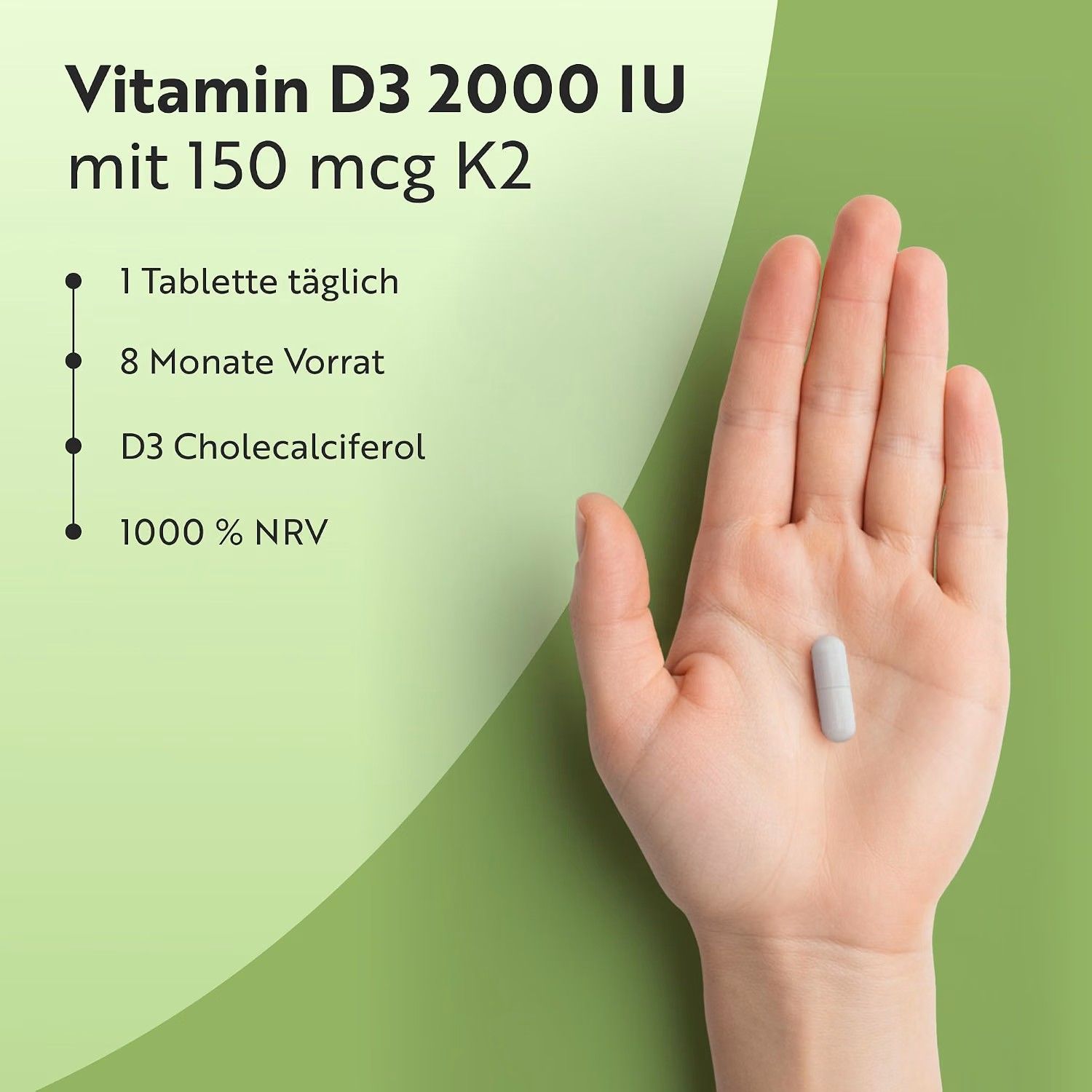 Hand hält eine einzelne Vitamin D3 2000 IE mit 150 mcg K2 Tablette.