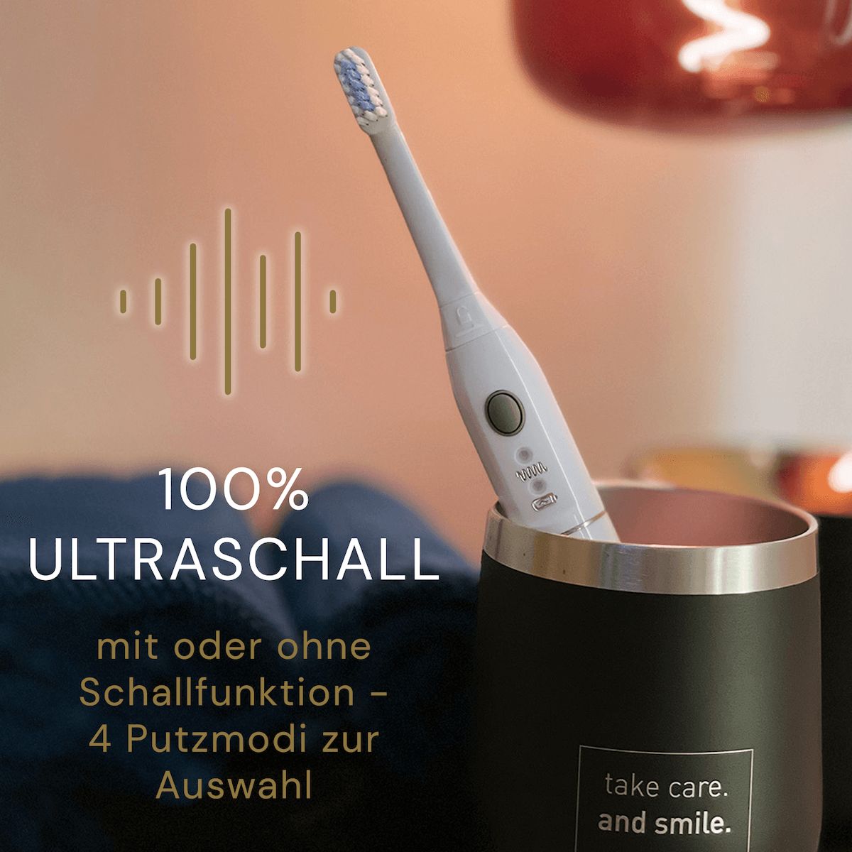 Elektrische Zahnbürste in schwarzem Becher. Text: 100% Ultraschall, mit oder ohne Schallfunktion - 4 Putzmodi zur Auswahl. Aufschrift: take care. and smile.