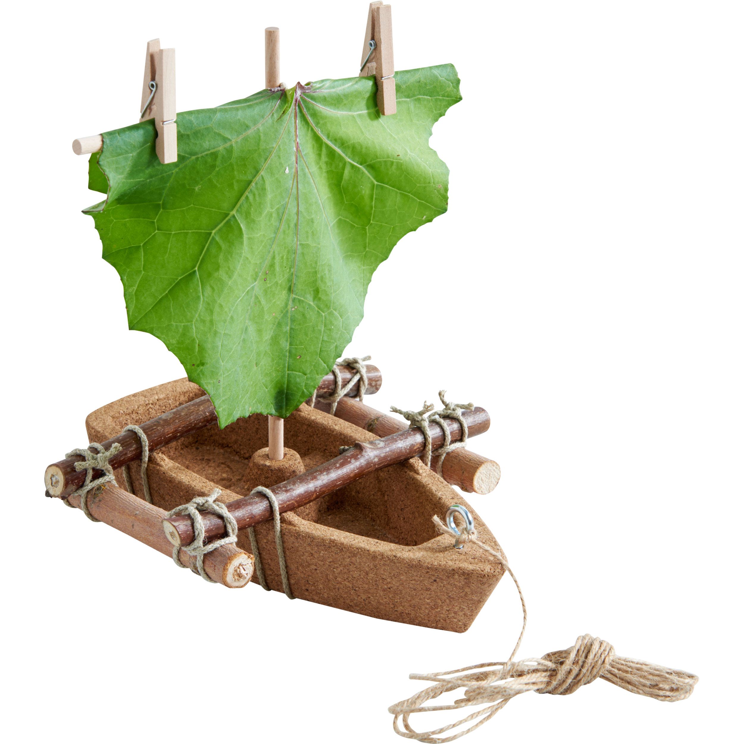 Korkboot mit Blattsegel. Segel aus Blatt, befestigt mit Wäscheklammern. Seil am Bug. Holzkonstruktion am Bug und Heck.
