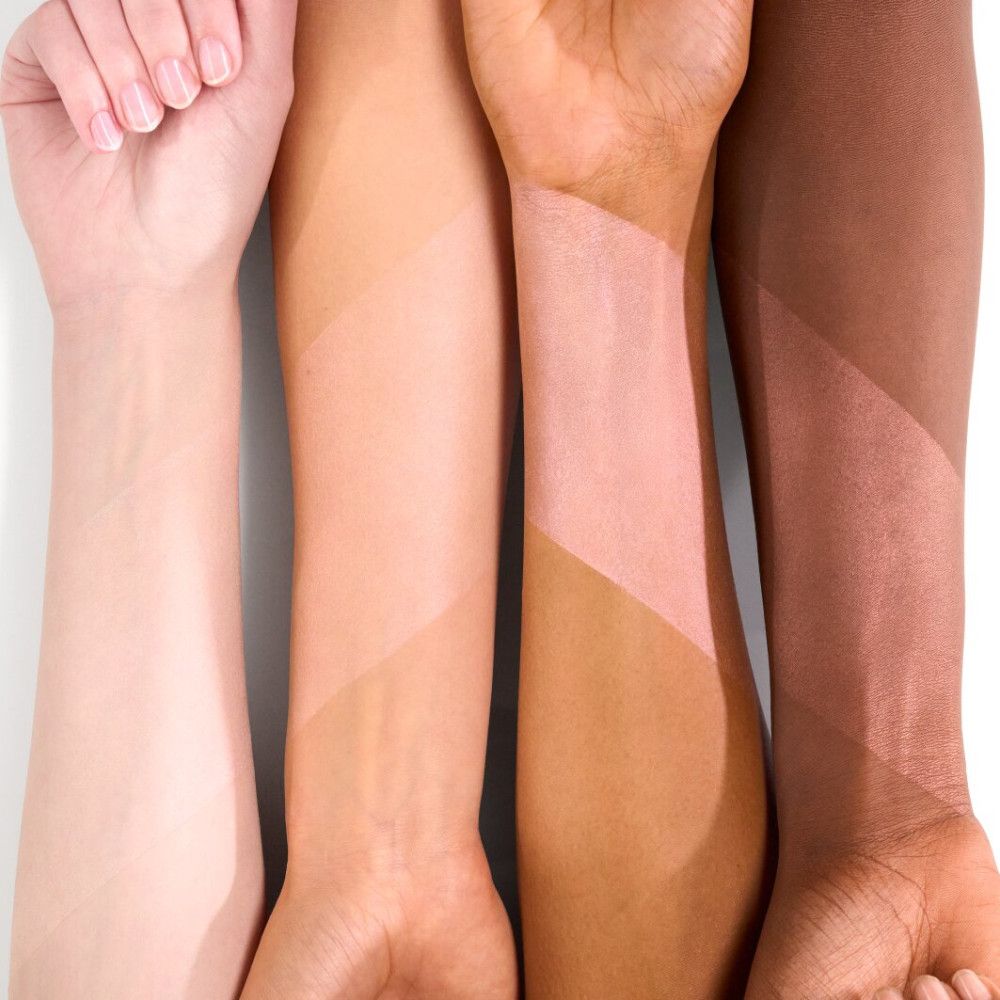 Arme mit aufgetragenem Primer. Vier Arme mit unterschiedlichen Hauttönen, auf denen Primer aufgetragen wurde.