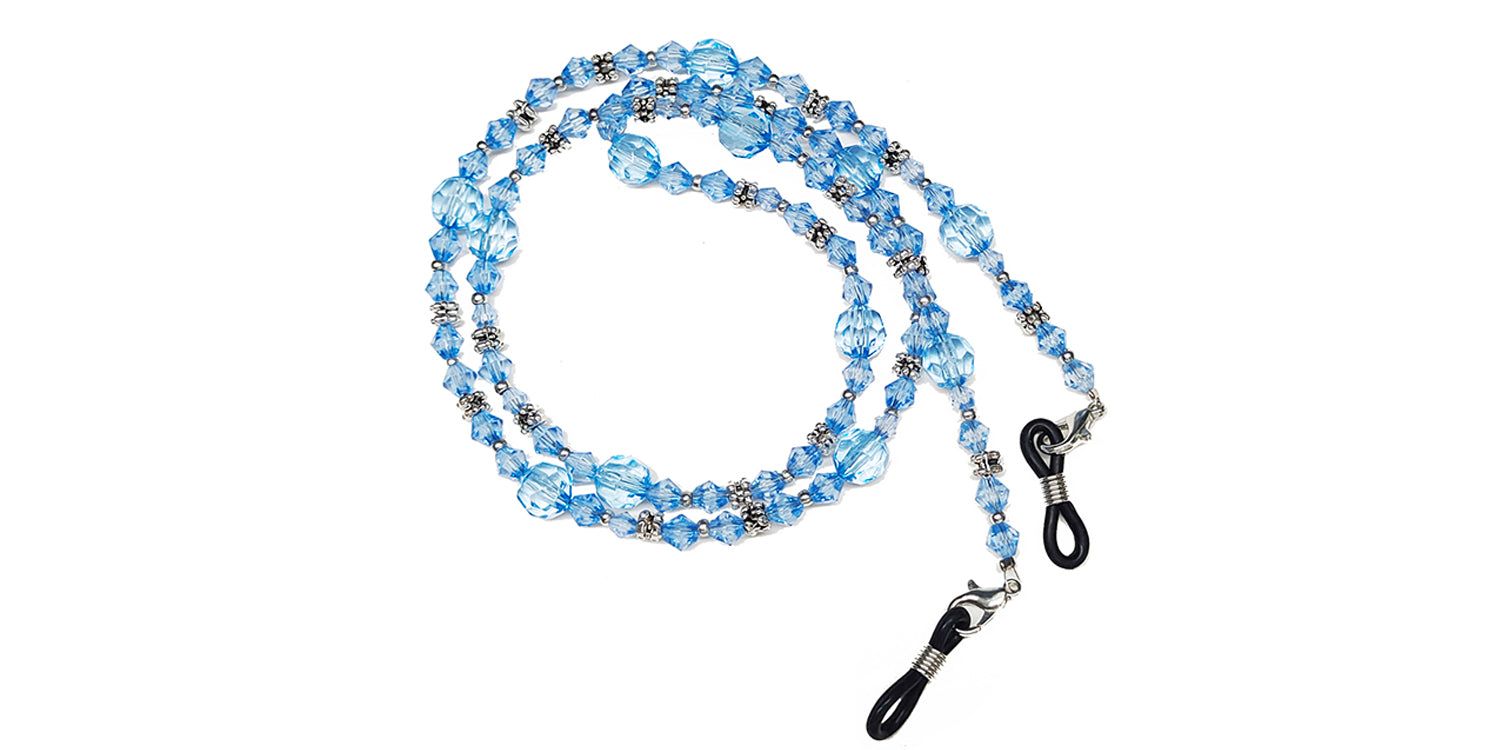 Brillenkette mit blauen Perlen und Metallakzenten. Enden mit Schlaufen zur Befestigung an Brillenbügeln.