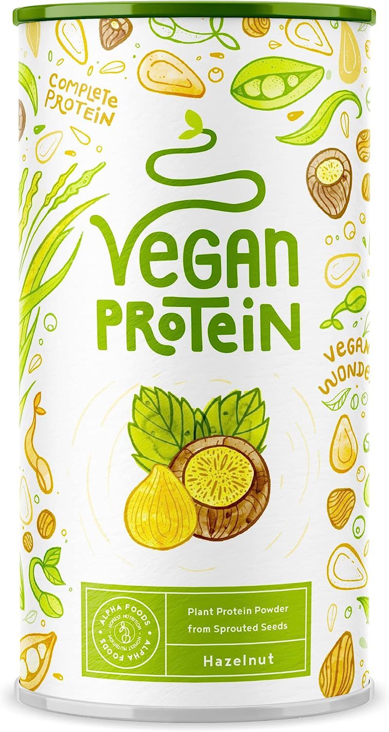 Zylindrische Dose mit "Vegan Protein"-Aufdruck, Haselnuss-Geschmack. Abbildung von Haselnuss und Blättern. "Alpha Foods"-Logo.