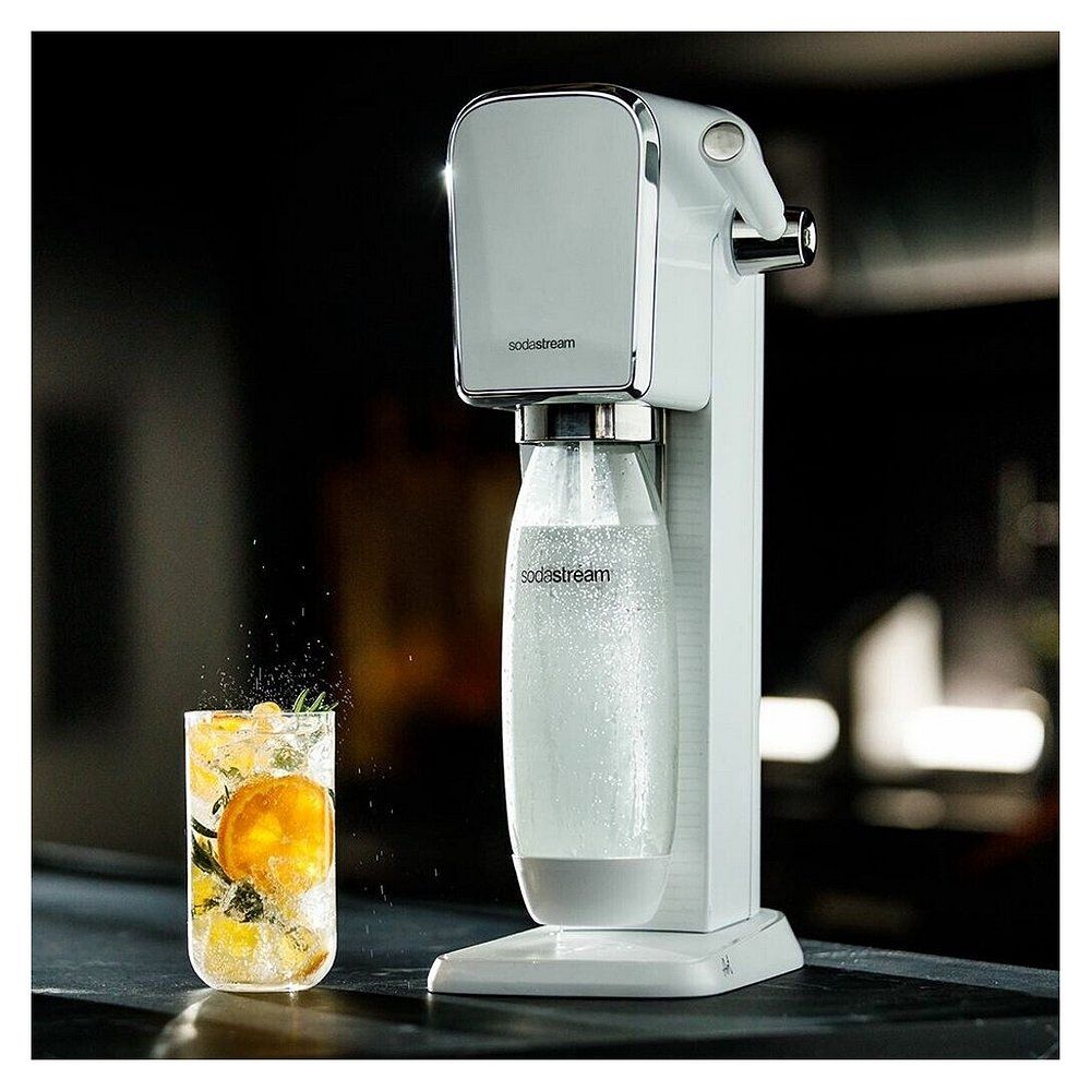 Weiße SodaStream Art Wassermaschine sprudelt Wasser in ein mit Früchten garniertes Glas.
