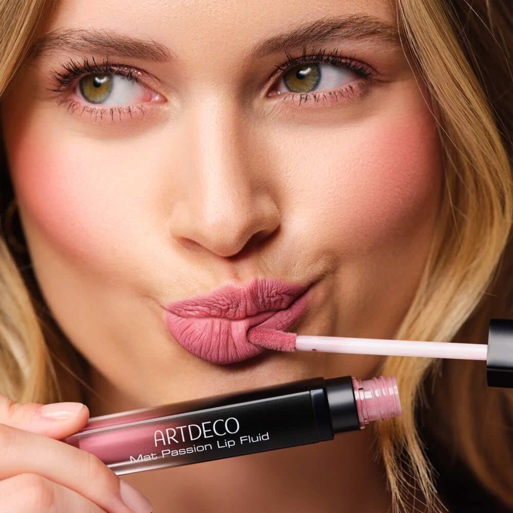 Frau mit Artdeco Mat Passion Lip Fluid. Produkt und Applikator sichtbar. Lippenfarbe wird aufgetragen.
