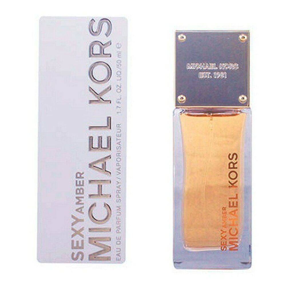 Parfümflasche und Verpackung. Aufschrift: MICHAEL KORS SEXY AMBER. Goldfarbene Schrift auf weißem Hintergrund. Flasche mit goldfarbenem Deckel.