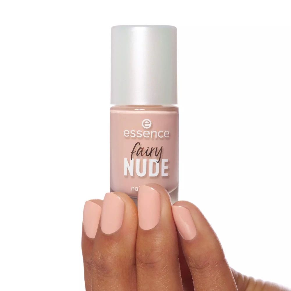 Hand mit lackierten Nägeln in Nude-Farbe. Essence Fairy Nude Nagellack-Fläschchen daneben. Schriftzug: Essence, Fairy Nude, nail polish.