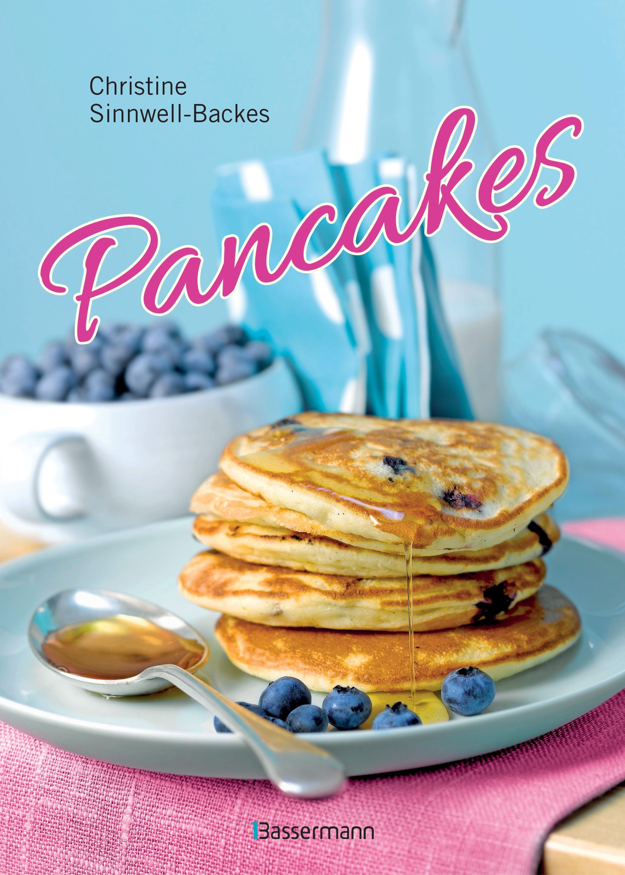 Buchcover mit Pancakes-Titel. Autorin: Christine Sinnwell-Backes. Blaubeeren, Ahornsirup und Teller.