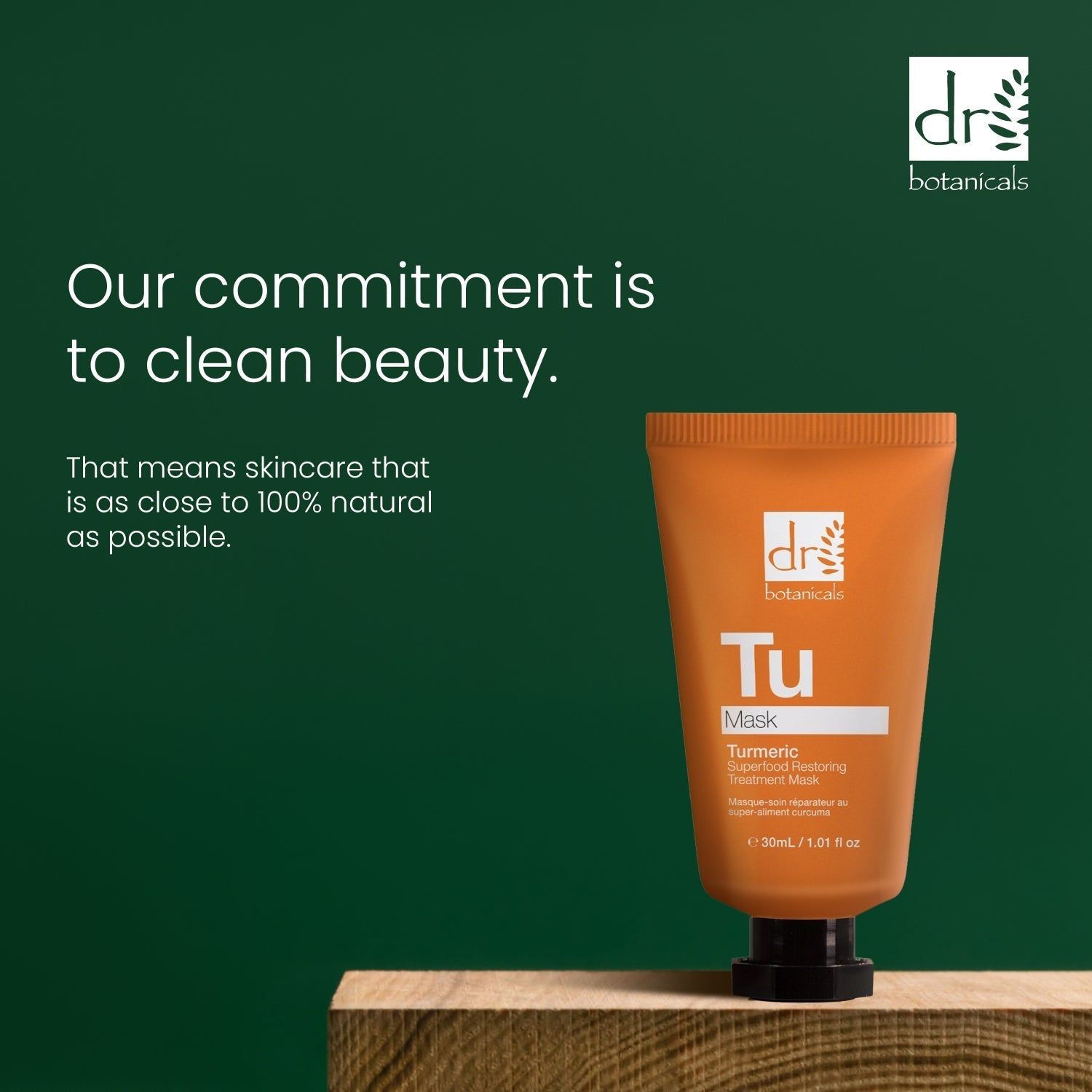 Orange Tube auf Holzblock. Text: Our commitment is to clean beauty. Marke: Dr Botanicals. Hintergrund: Grün.