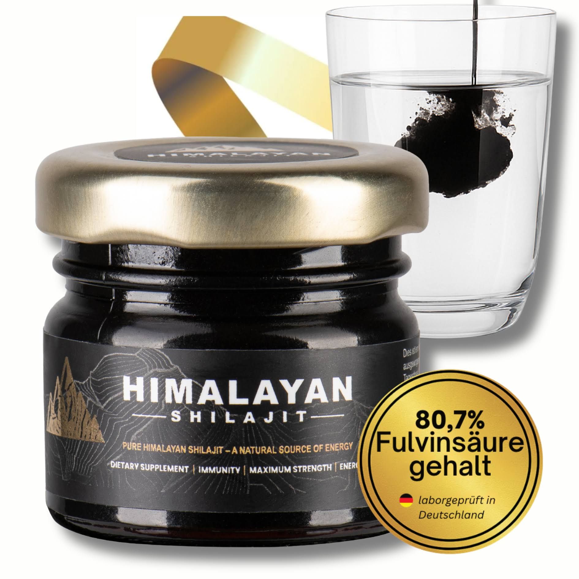 Glas mit schwarzem Shilajit, Dosierlöffel und Glas Wasser. Goldener Aufkleber mit 80,7% Fulvinsäure. Laborgeprüft in Deutschland.