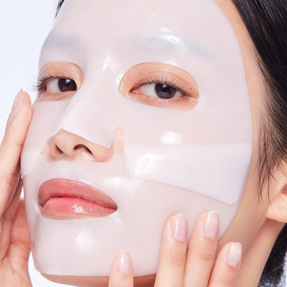 Nahaufnahme eines Gesichts mit einer Maske. Die Maske bedeckt die Haut. Hände berühren die Maske. Weiße Maske.