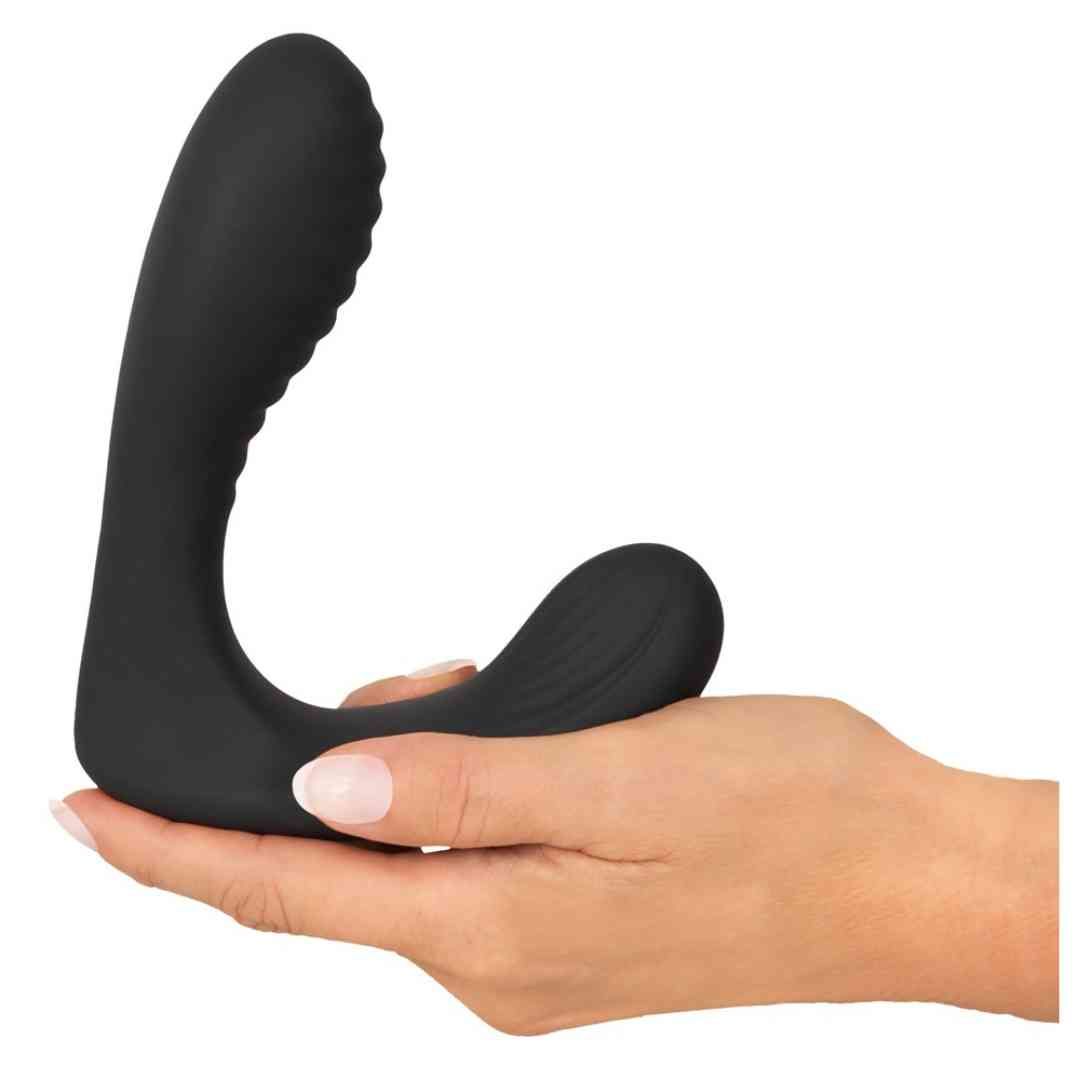 Schwarzer, U-förmiger Plug, geriffelte Oberfläche, in Hand gehalten. Glatte Oberfläche.