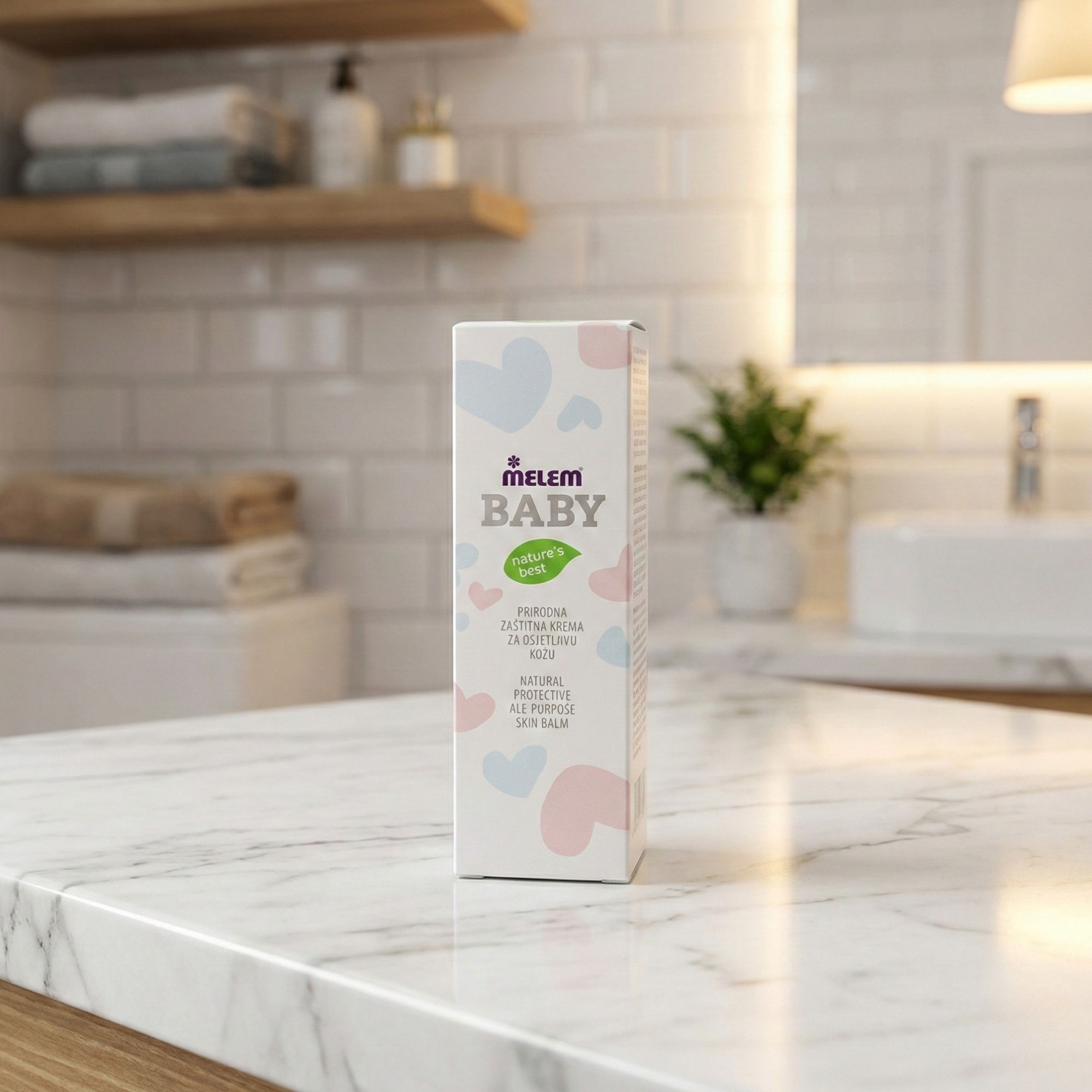 Kartonverpackung "Melem Baby" auf einer Marmoroberfläche. Text: "Natural Protective All-Purpose Skin Balm". Badezimmerhintergrund.