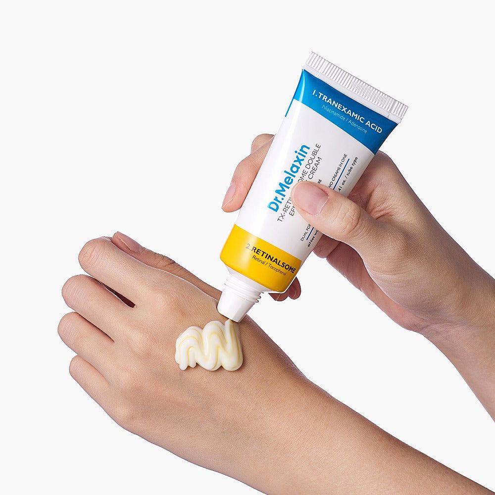 Eine Hand drückt eine doppelseitige Augencreme aus, eine weiße und eine gelbe Creme werden auf die andere Hand aufgetragen.