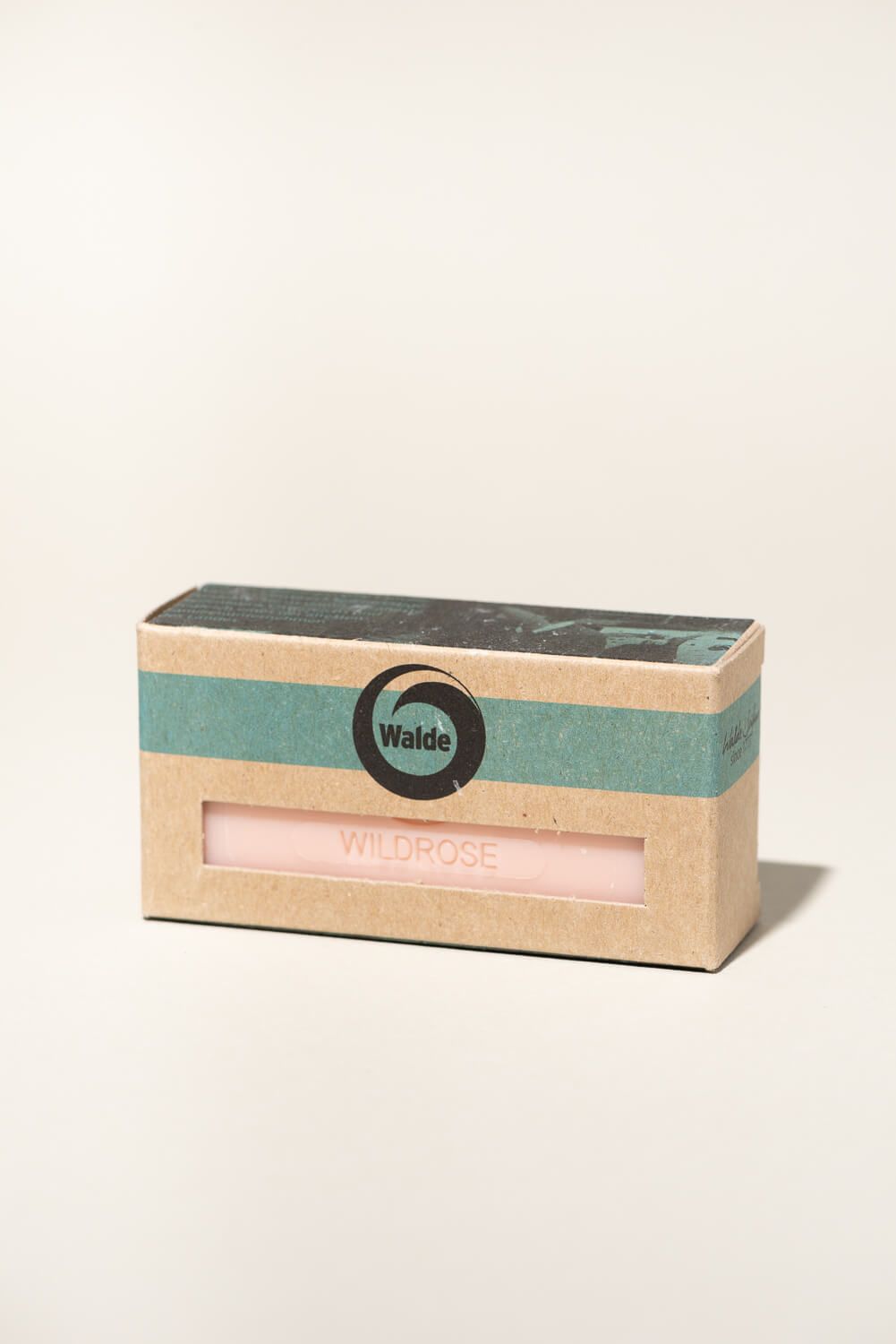 Seife in Kartonverpackung. Aufdruck "Walde" und "Wildrose". Rosa Seife durch Fenster sichtbar.