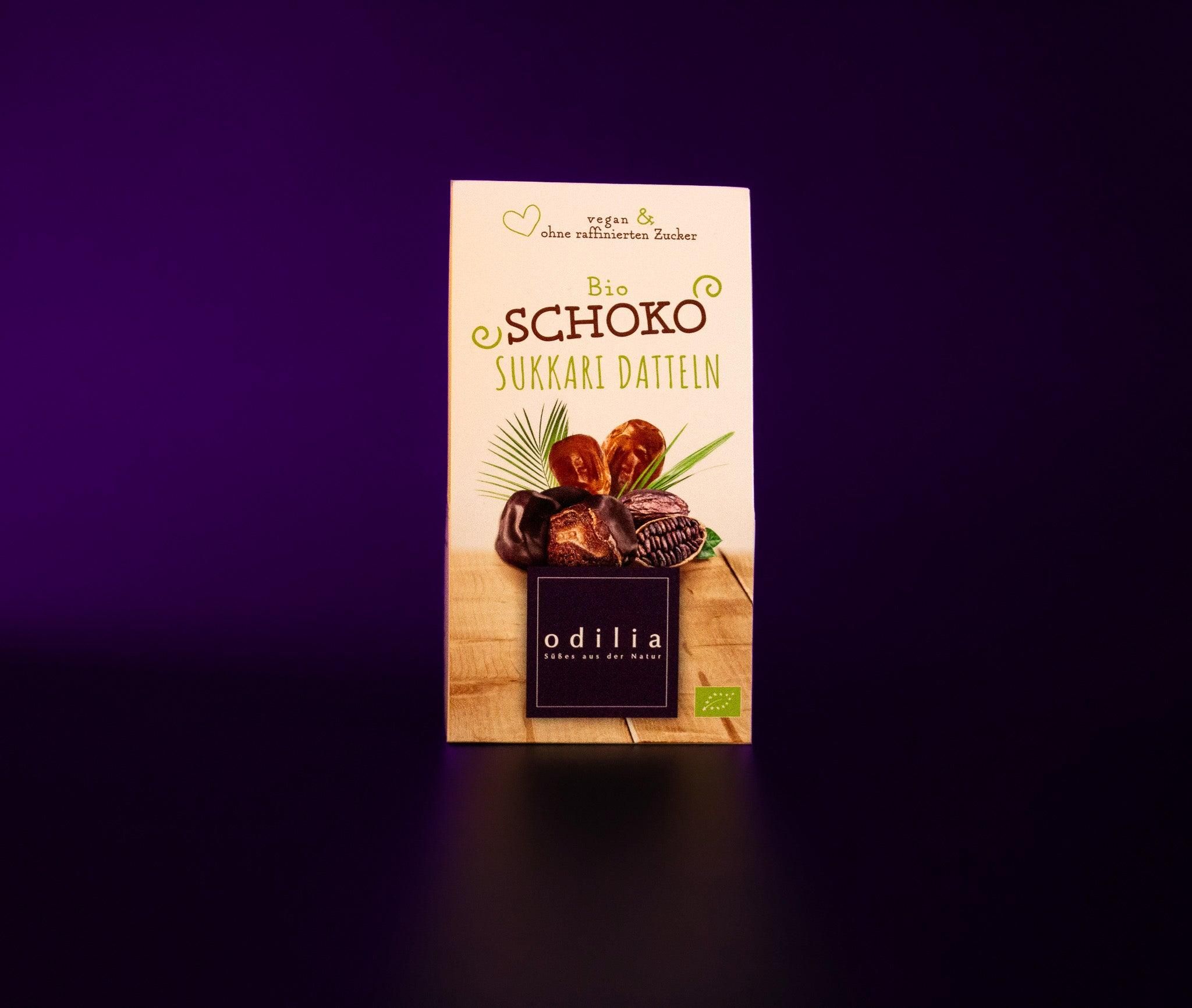 Verpackung von Bio Schoko Sukkari Datteln mit Palmblättern und Kakao.