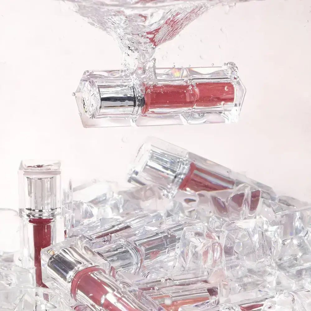 Lippenstifte in transparenten Behältern in Eiswürfeln und Wasser. Mehrere Lippenstifte.