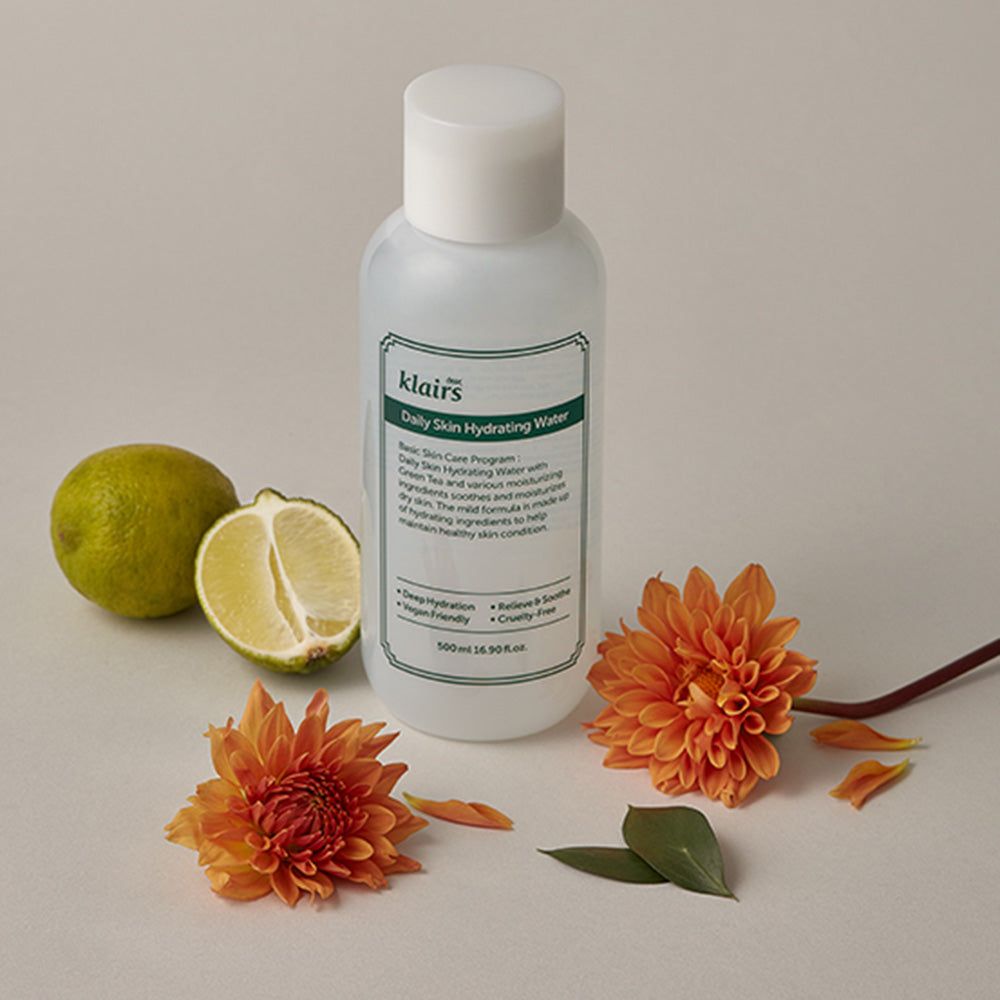 Weiße Flasche mit grünem Etikett. Text: "klairs Daily Skin Hydrating Water". Daneben Limette und Blüten.