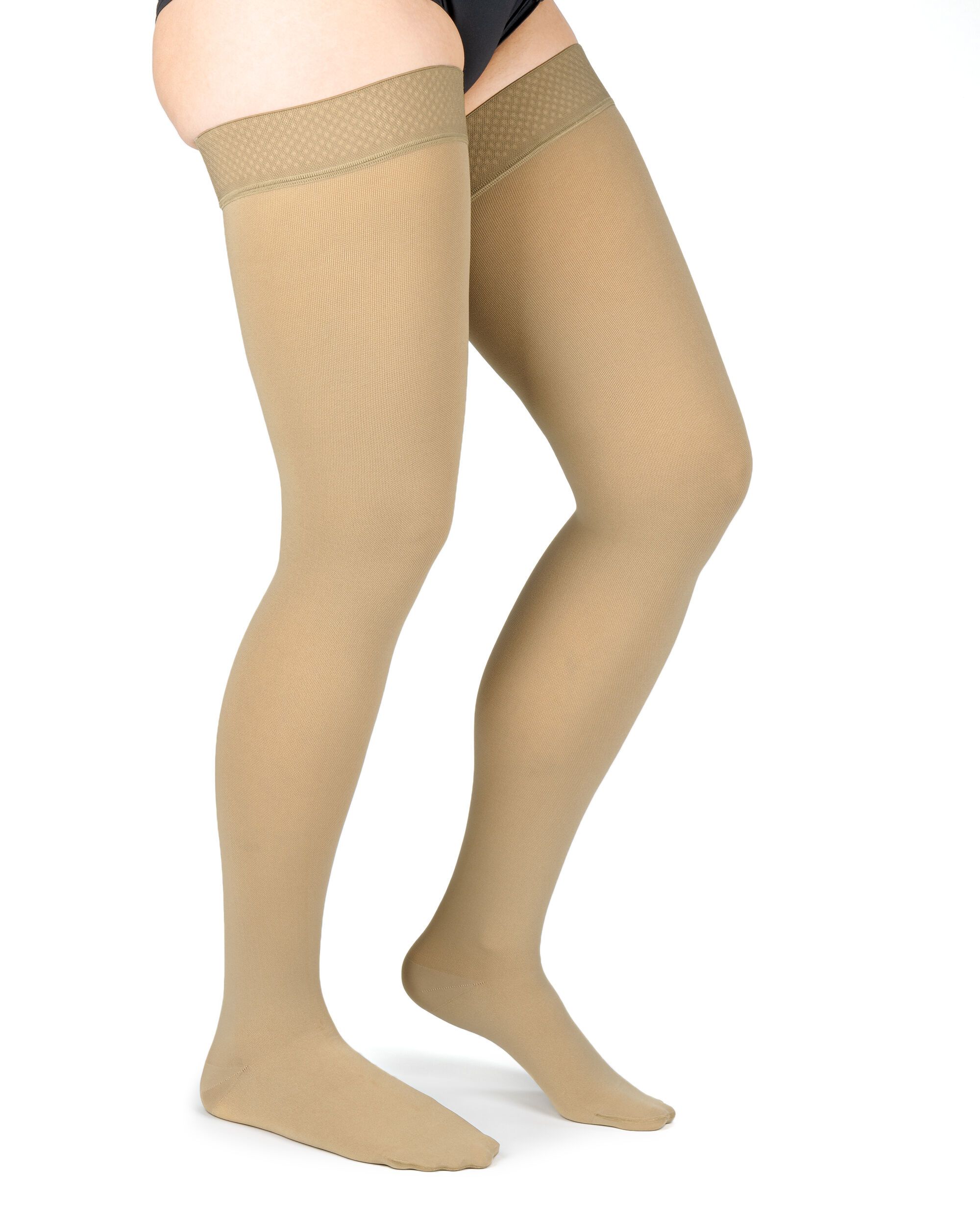 Hautfarbene Kompressionsstrümpfe bis zum Oberschenkel. Mit strukturiertem Abschlussband. Blick von der Seite, auf einem weißen Hintergrund.
