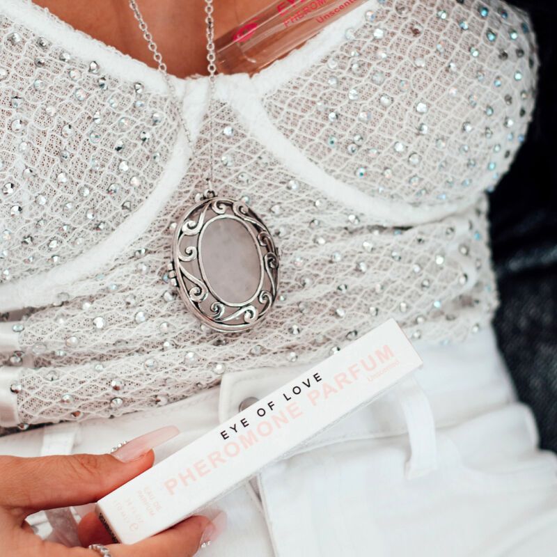 Verpackung und Flakon. Aufschrift: EYE OF LOVE PHEROMONE PARFUM. Frau trägt Oberteil mit Schmuck.