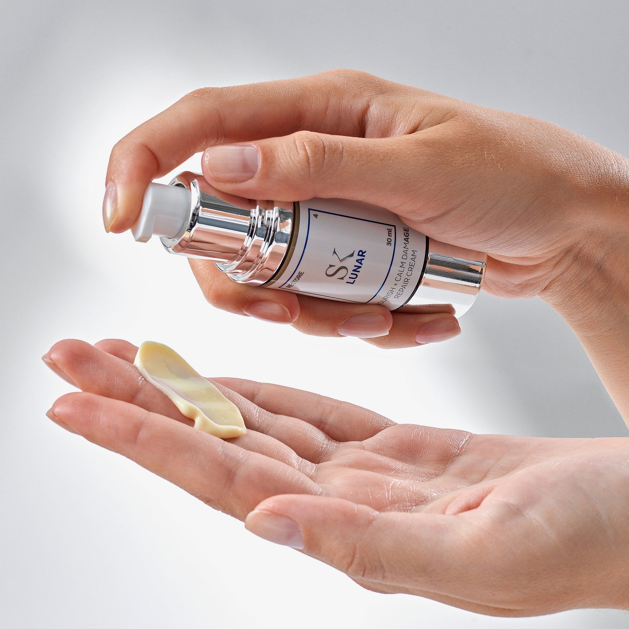 Hände halten Creme und Spender. Aufschrift: SK Lunar. Creme-Strang in der Handfläche.