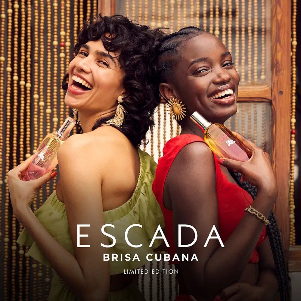 Zwei Frauen halten Escada Brisa Cubana Flakons. Aufschrift: ESCADA BRISA CUBANA LIMITED EDITION. Frauen lächeln.