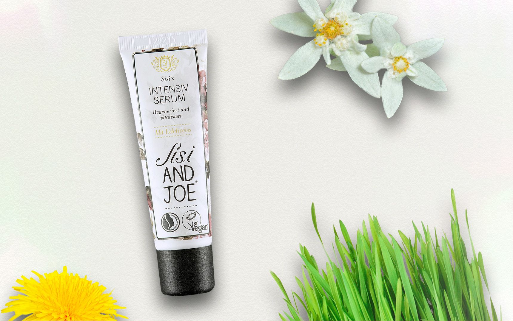 Tube mit "Intensiv Serum" und "sisi AND JOE" Schriftzug. Neben Blumen und Gras.