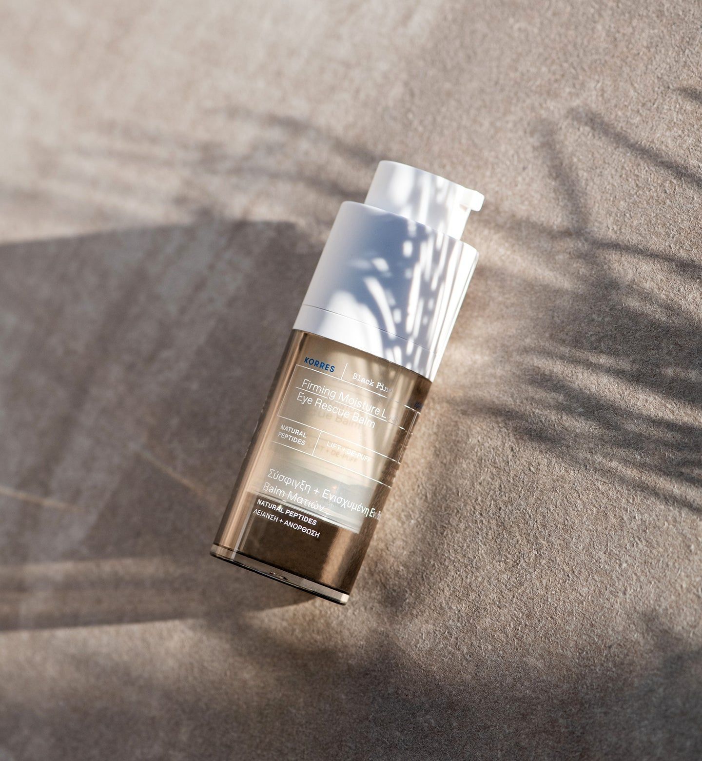 Produktflasche mit Spender. Marke KORRES, Produktname auf Etikett. Auf sandfarbenem Untergrund.