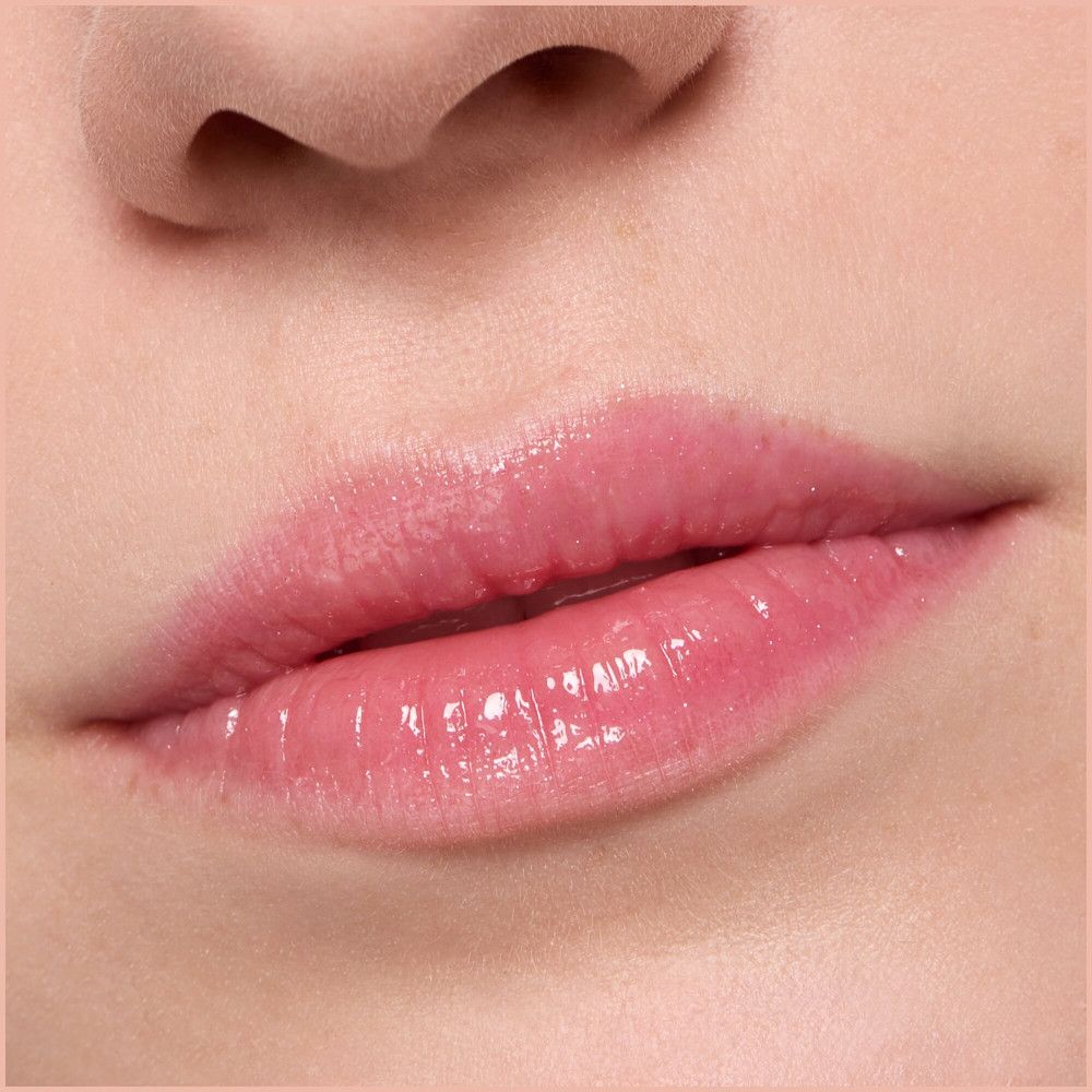 Nahaufnahme von Lippen mit glänzendem, rosa Lipgloss. Keine weiteren Details.
